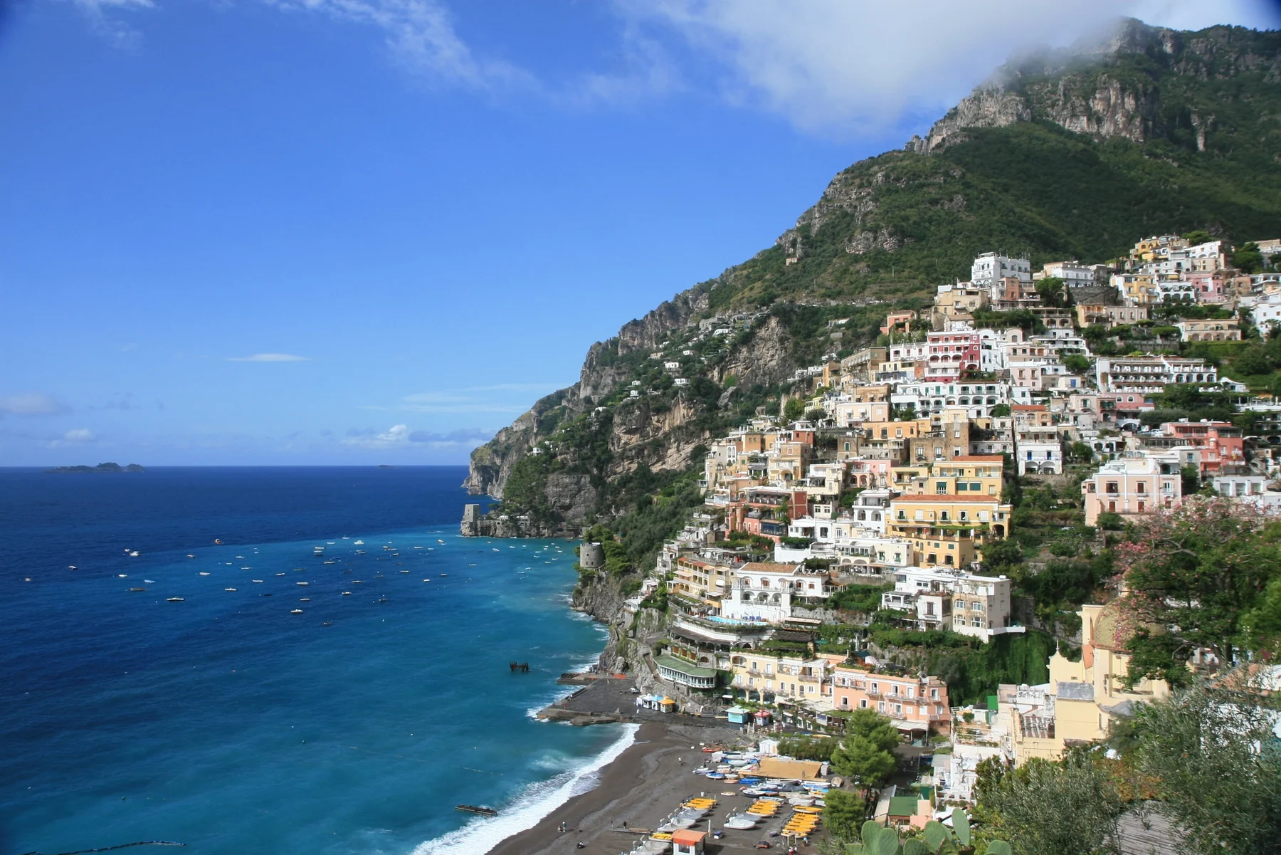 Farverige huse, strand og blåt hav i Positano på Amalfikysten