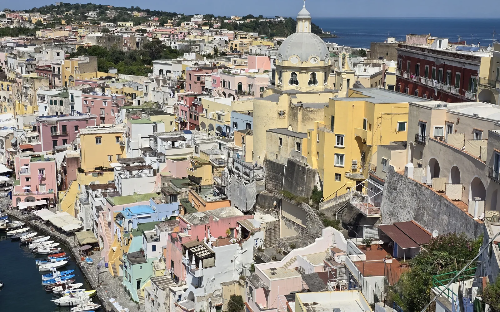 Farverige huse og fiskerbåde i Marina Corricella på Procida